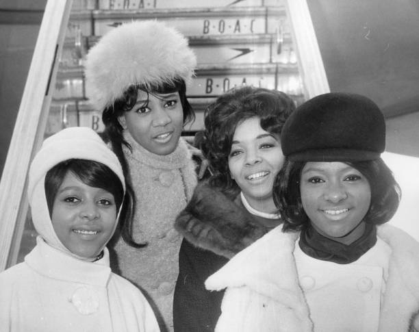 Phil Spector's American soul singing group The Crystals, from left to right; Barbara, Dee Dee, Fran and La La, all wrapped up at London Airport for...